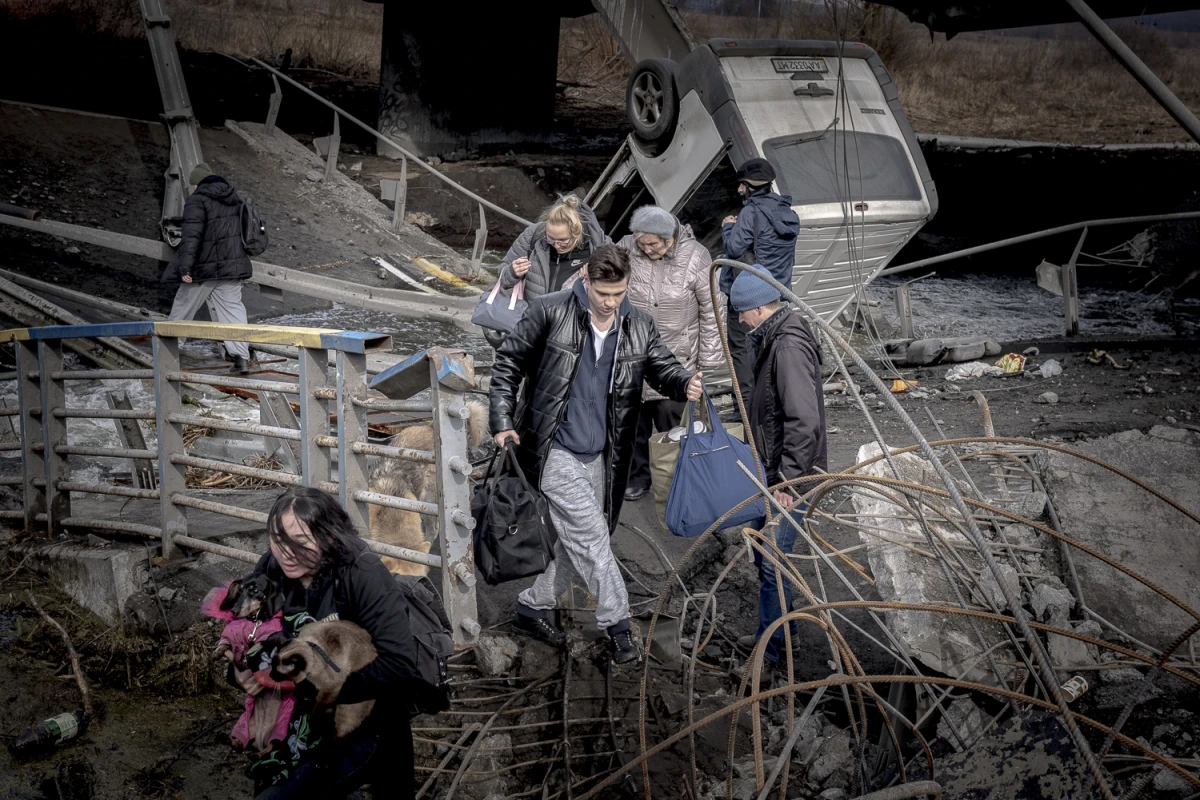 A family with three kids gather at the evacuation point in Romanivka fleeing the combats