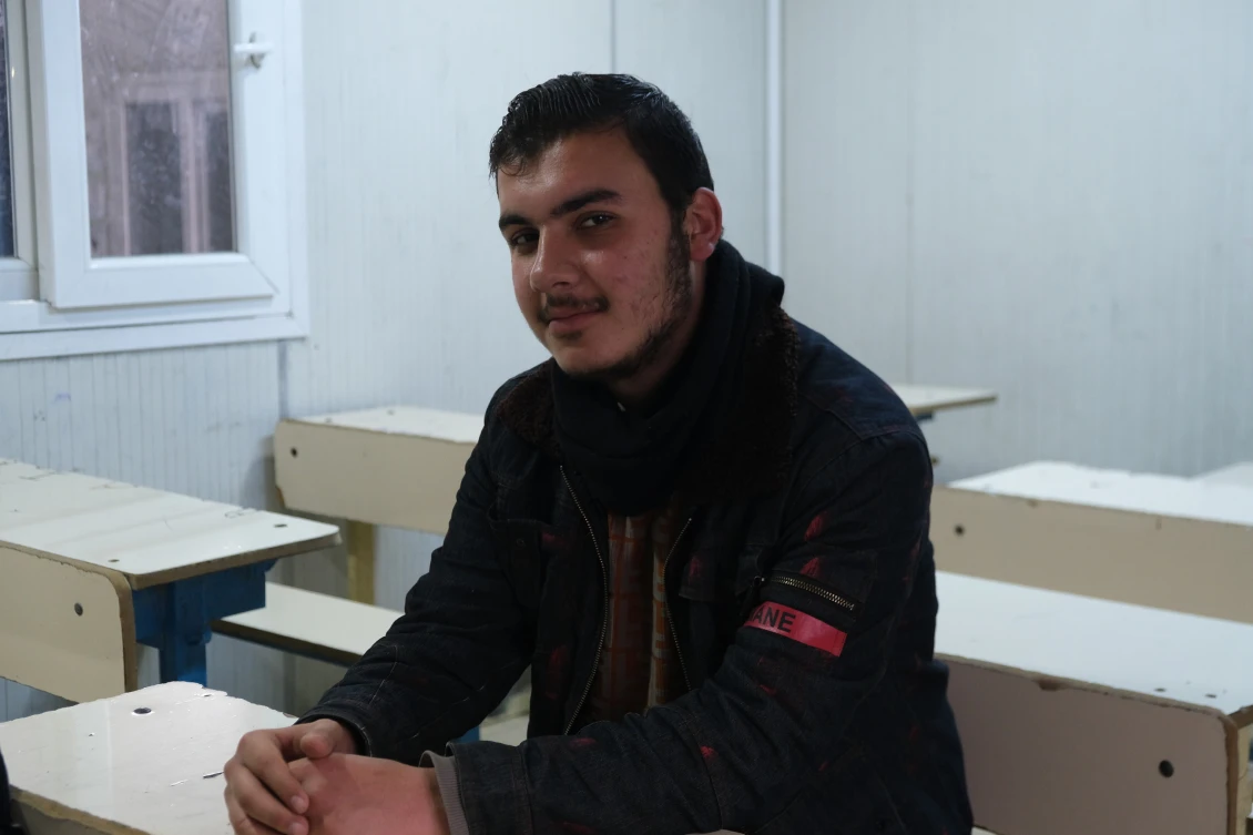Mostafa, 16 let, v lavici jedné z tříd ve škole v kempu Basrama. 