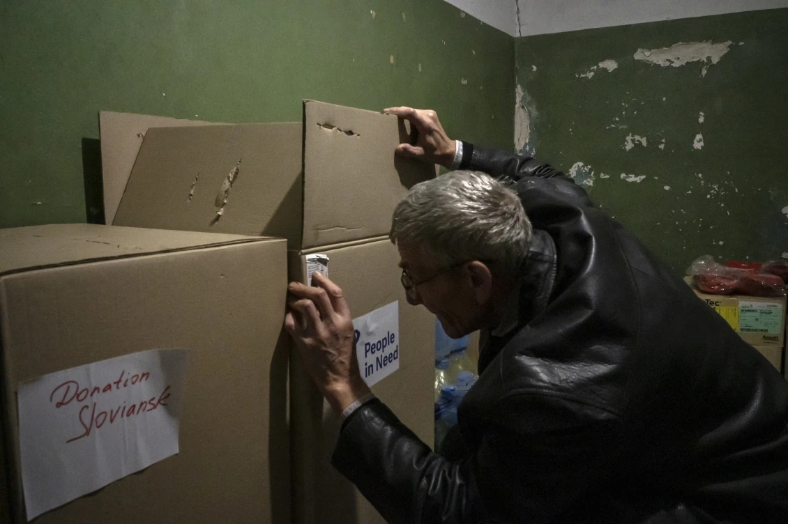 Nemocniční zaměstnanec kontroluje krabice s humanitární pomocí. 
