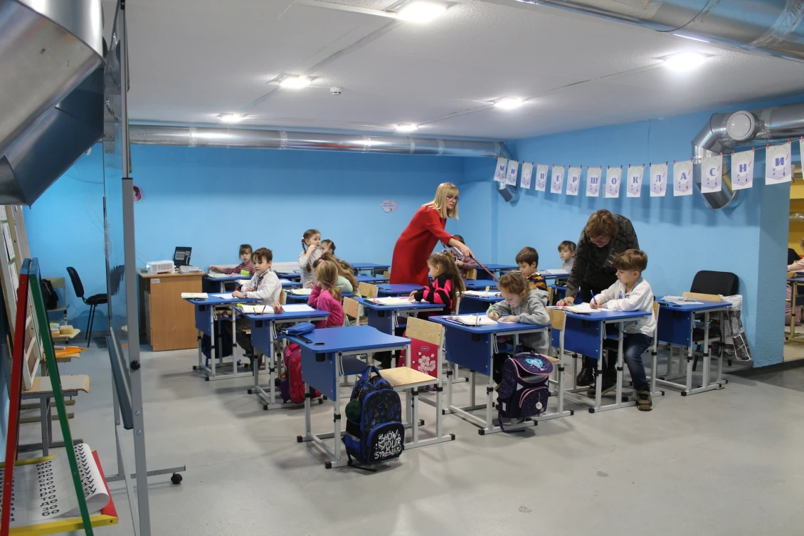 Prvňáci, kteří se učí v bezpečnostním krytu.