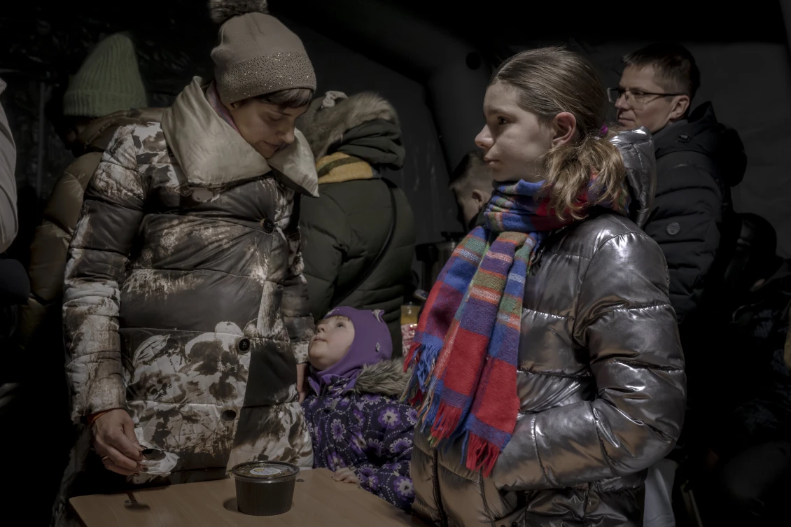 Daria (33 let) a její dcery Vira a Serafima jsou v místě, kde jsou v bezpečí a stále nedaleko svého domova na okraji Kyjeva. Přišly si pro teplou polévku a ukrýt se před mrazivým chladem.